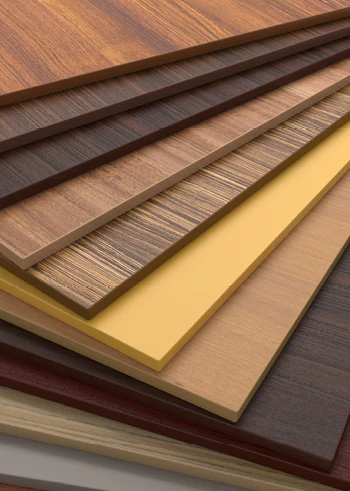 Verschiedene Holzwerkstoffplatten mit unterschiedlichen Dekoren und Farben, ideal für Möbel- und Innenausbau.