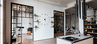 Türen im Loft-Stil mit schwarzen Metallrahmenelementen verbinden Küche und Wohnbereich.